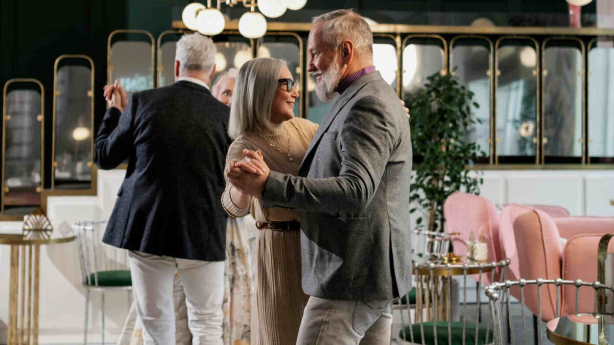 an old couple at an event slow dance, sway and serenade