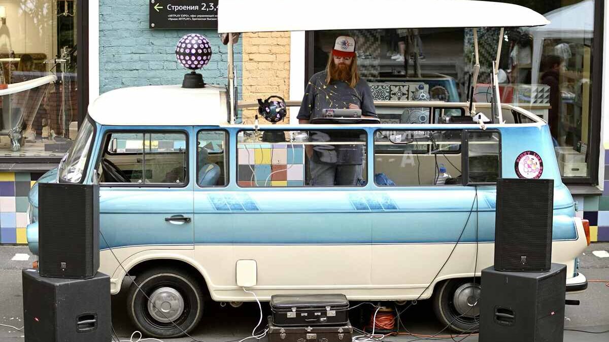 man with dj setup around his vw camper van showcasing work as a mobile DJ vs. club DJ