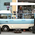 man with dj setup around his vw camper van showcasing work as a mobile DJ vs. club DJ