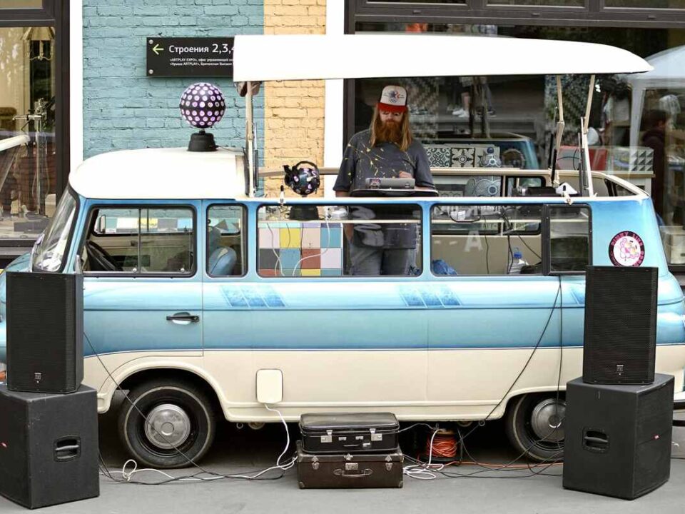 man with dj setup around his vw camper van showcasing work as a mobile DJ vs. club DJ
