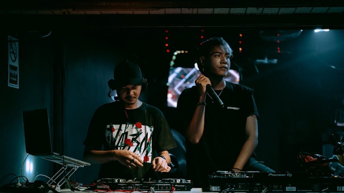 person with mic standing next to a dj to illustrate how to deal withl difficult situations at a bar