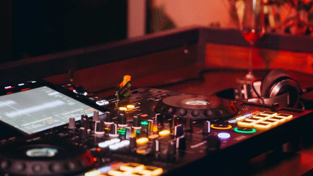 Wedding DJ booth at a South African reception, clean setup, glowing lights, and a full dance floor reacting to the music.