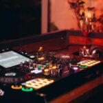 Wedding DJ booth at a South African reception, clean setup, glowing lights, and a full dance floor reacting to the music.