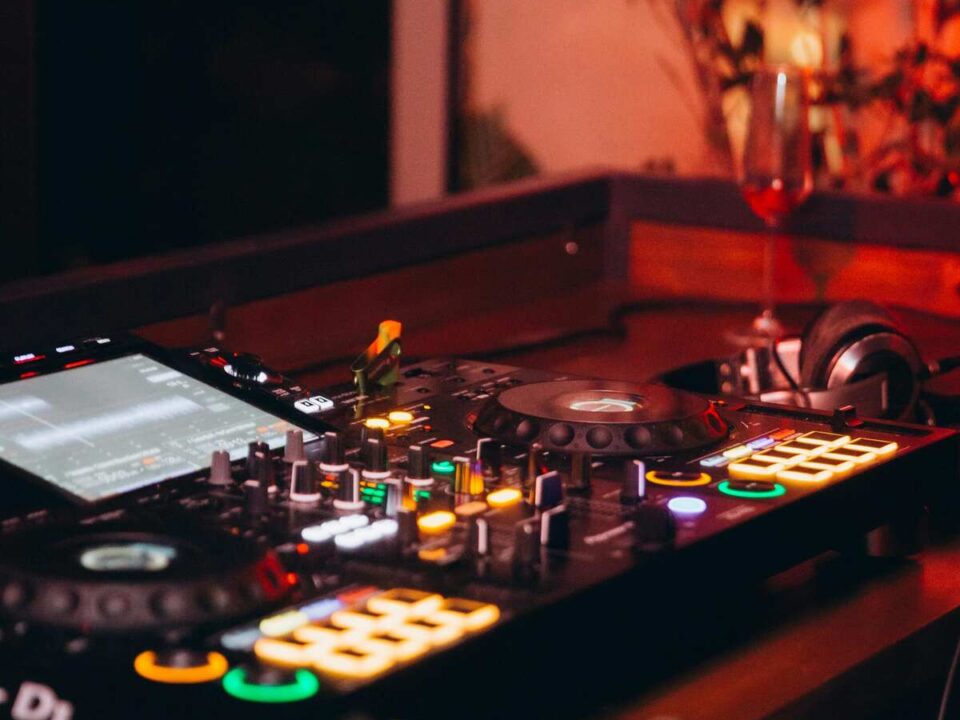 Wedding DJ booth at a South African reception, clean setup, glowing lights, and a full dance floor reacting to the music.